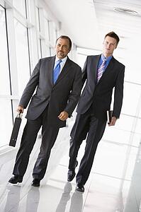 Two businessmen walking in a corridor (high key/selective focus)
