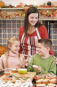 Mother and two children at Halloween making treats and smiling