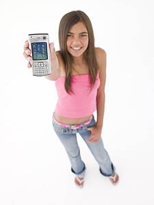 Young girl holding up cellular phone and smiling