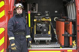 Rescue worker standing by open back door of rescue vehicle