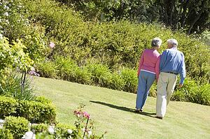 Senior couple walking through a flower garden