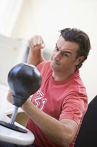 Businessman in office using small punching bag to relieve stress
