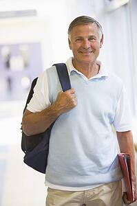 Man standing in corridor with backpack (high key)