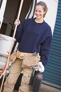 Plumber standing with van smiling