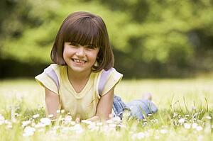 Young girl lying outdoors smiling