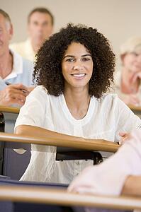 Woman sitting in adult classroom with students in background (selective focus)