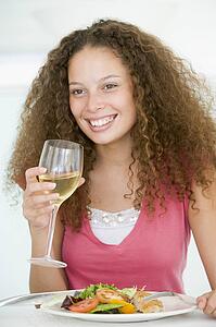 Woman Eating meal, mealtime With A Glass Of Wine 