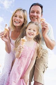 Family standing outdoors with ice cream smiling