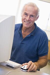 Man at computer smiling (high key)