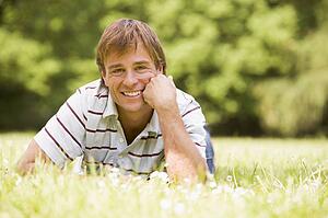 Man lying outdoors smiling