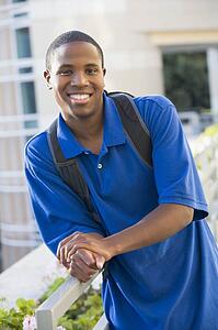 Man standing on balcony leaning on railing (selective focus)