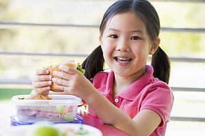 Student outdoors eating lunch (selective focus)