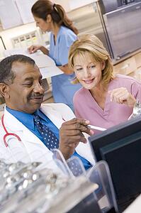A Doctor And Nurse Discussing Something At The Reception Area Of A Hospital