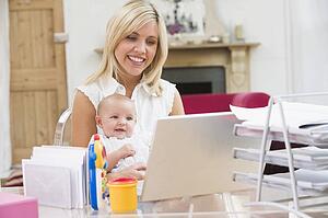Mother and baby in home office with laptop
