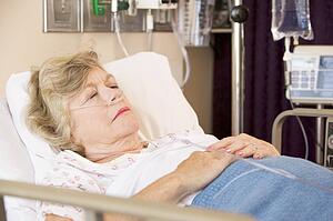 Senior Woman Sleeping In Hospital Bed