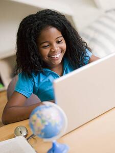 Young Girl Doing Her Homework On A Laptop