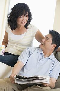Couple relaxing with a newspaper and smiling