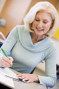 Adult student in class taking notes