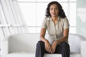 Businesswoman sitting indoors (high key/selective focus)