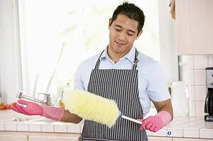 Man Holding Duster And Wearing Rubber Gloves