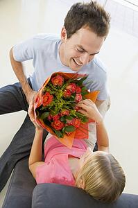 Husband giving wife flowers and smiling