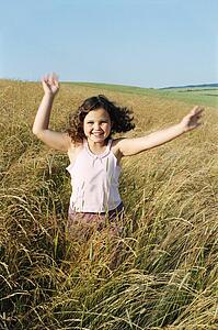 Young girl running outdoors smiling