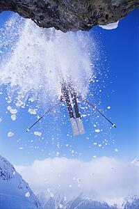 Skier jumping off snowy cliff