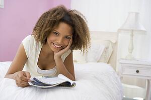 Teenage Girl Lying On Bed Reading