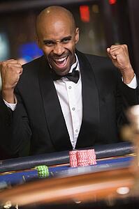 Man in casino winning roulette and smiling (selective focus)