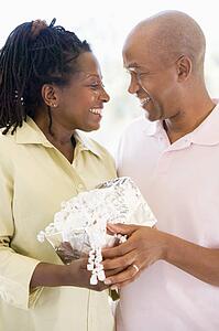 Husband and wife holding gift smiling