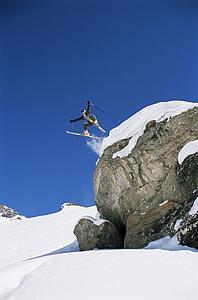Skier jumping off cliff (far away)