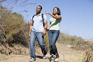 Couple walking on path holding hands and smiling