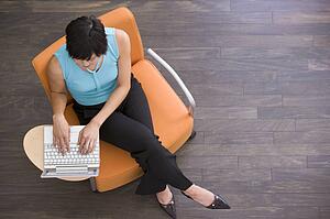 Businesswoman sitting indoors with laptop