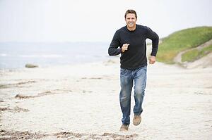 Man running at beach smiling