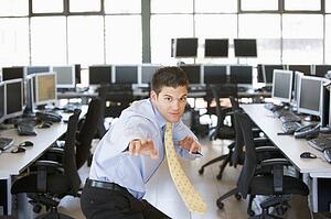 Businessman standing in karate stance in computer room