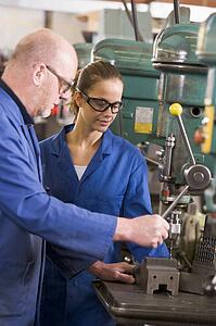 Two machinists working on machine