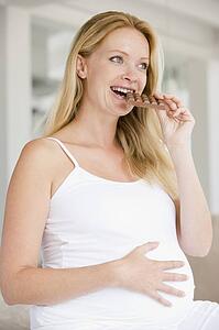 Pregnant woman with chocolate smiling