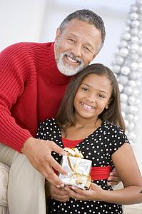 Grandfather Giving His Granddaughter A Christmas Present