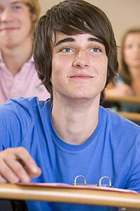 Student in class taking notes (selective focus)