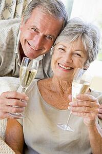 Couple in living room drinking champagne and smiling