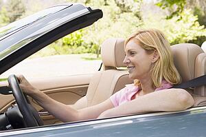 Woman in convertible car smiling