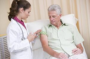 Doctor giving man needle in exam room