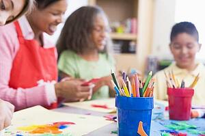 Teacher and students in art class with supplies in foreground (selective focus)