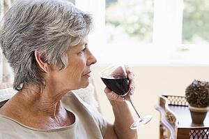 Woman in living room with glass of wine