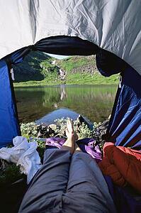 Man's legs in a tent overlooking scenic location