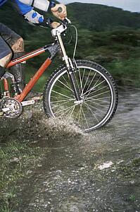 Man outdoors on trails riding bicycle (selective focus)