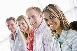 Four businesspeople sitting indoors smiling