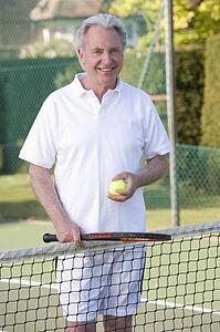 Man playing tennis and smiling