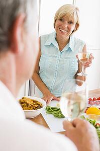 Woman Talking To Husband As She Prepares A meal, mealtime