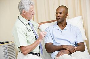 Doctor giving man checkup in exam room